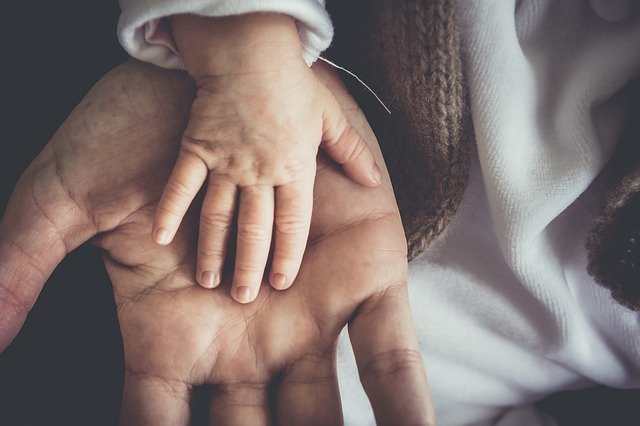 La main d'un bébé sur la main de son papa